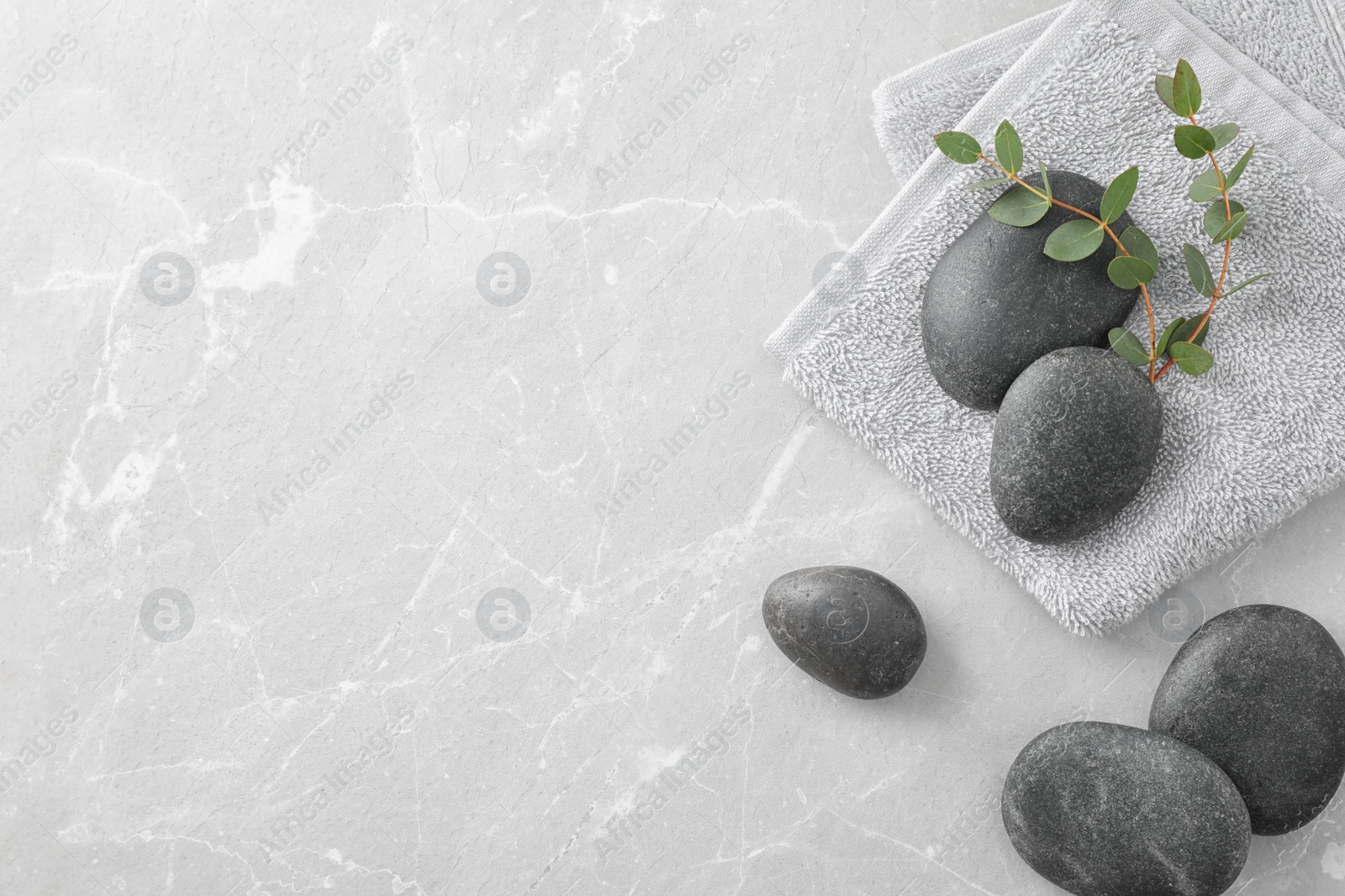 Photo of Flat lay composition with spa stones and green leaves on grey table, space for text