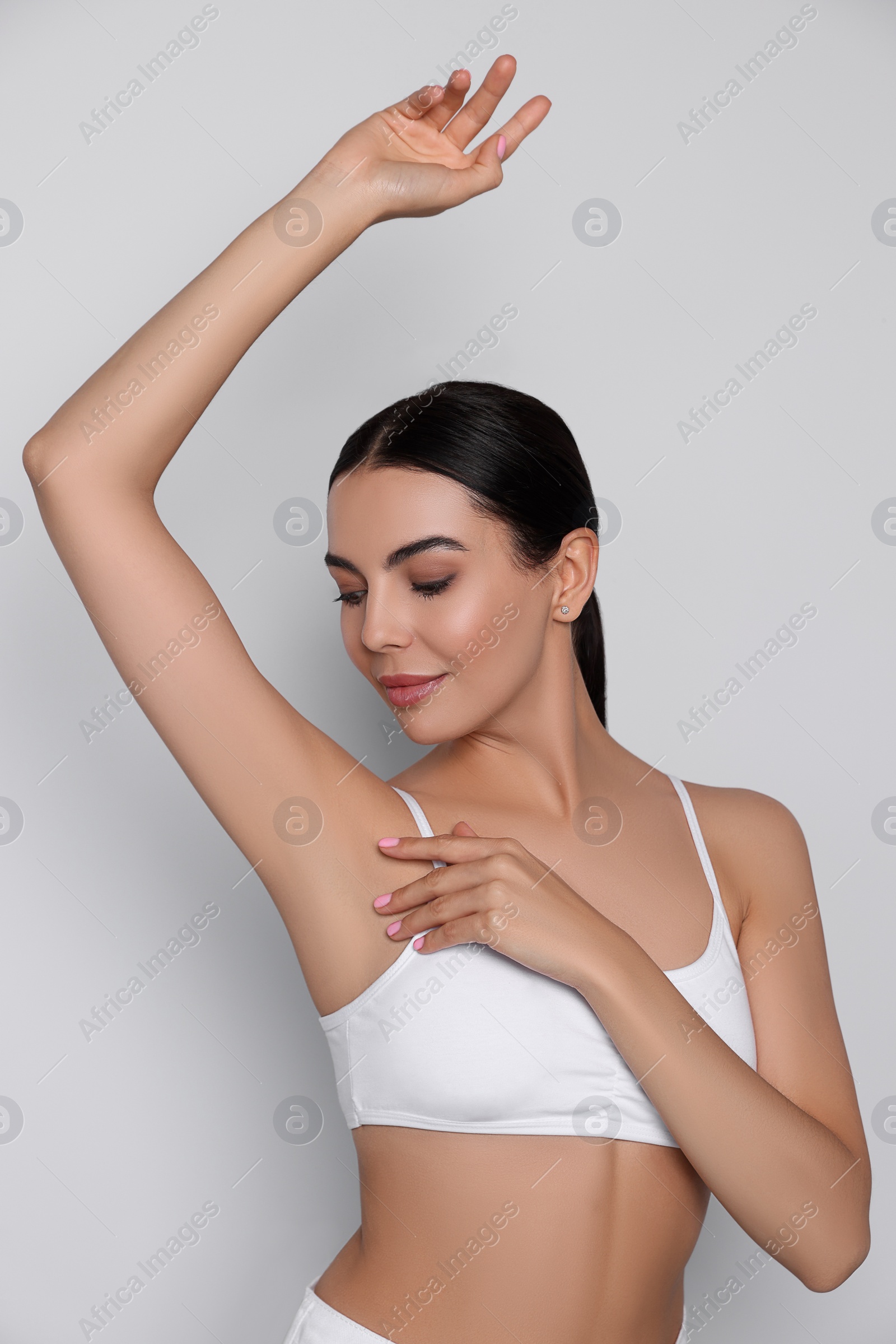 Photo of Young woman showing smooth skin after epilation on white background