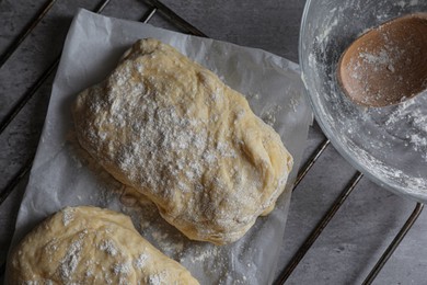 Raw dough for ciabatta and flour on grey table, flat lay