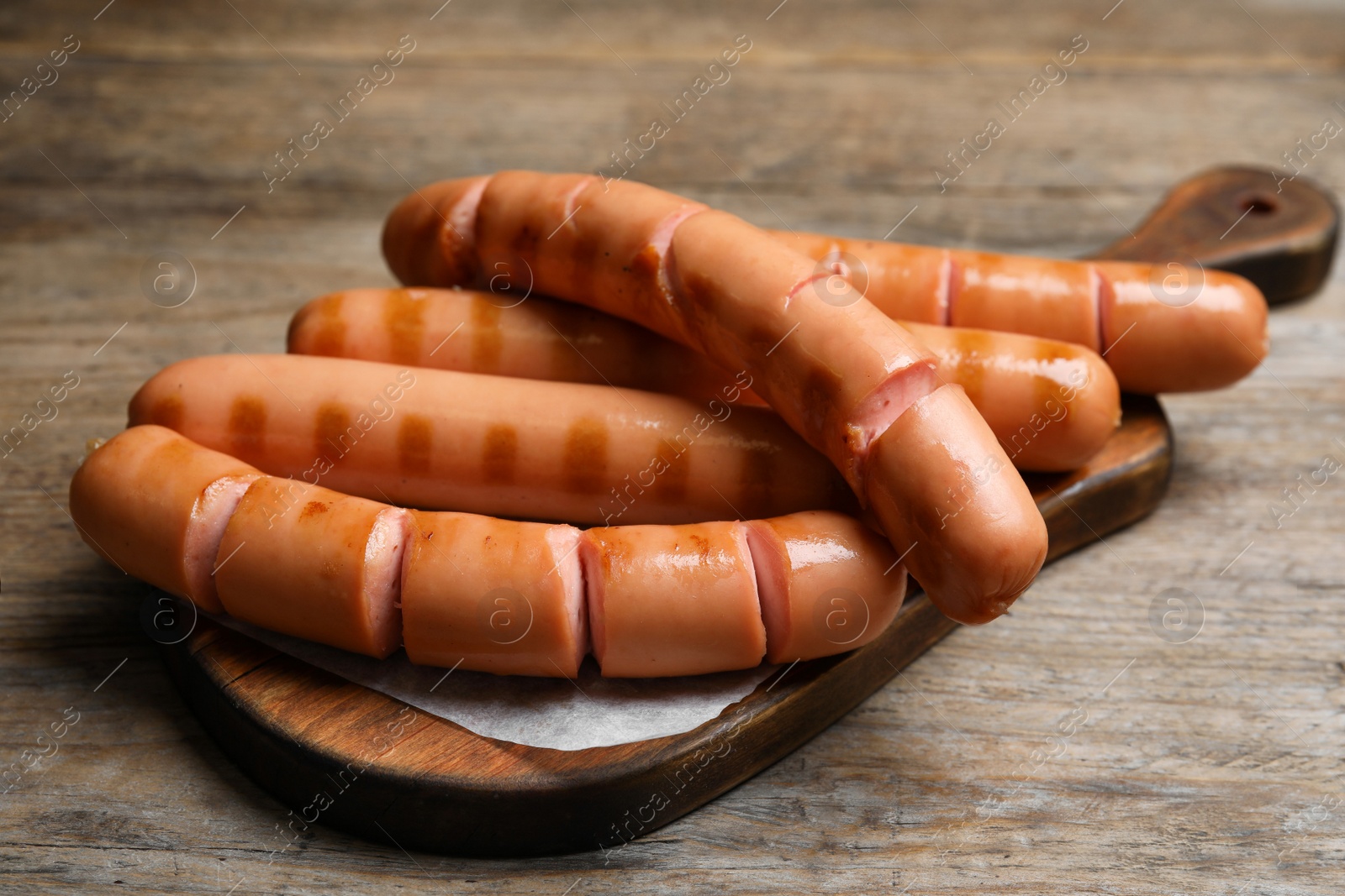 Photo of Delicious fresh grilled sausages on wooden table