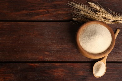 Photo of Semolina and spikelets on wooden table, flat lay. Space for text