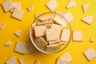 Photo of Delicious crackers on yellow background, flat lay