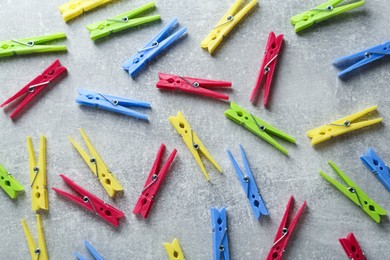 Photo of Colorful plastic clothespins on grey table, flat lay