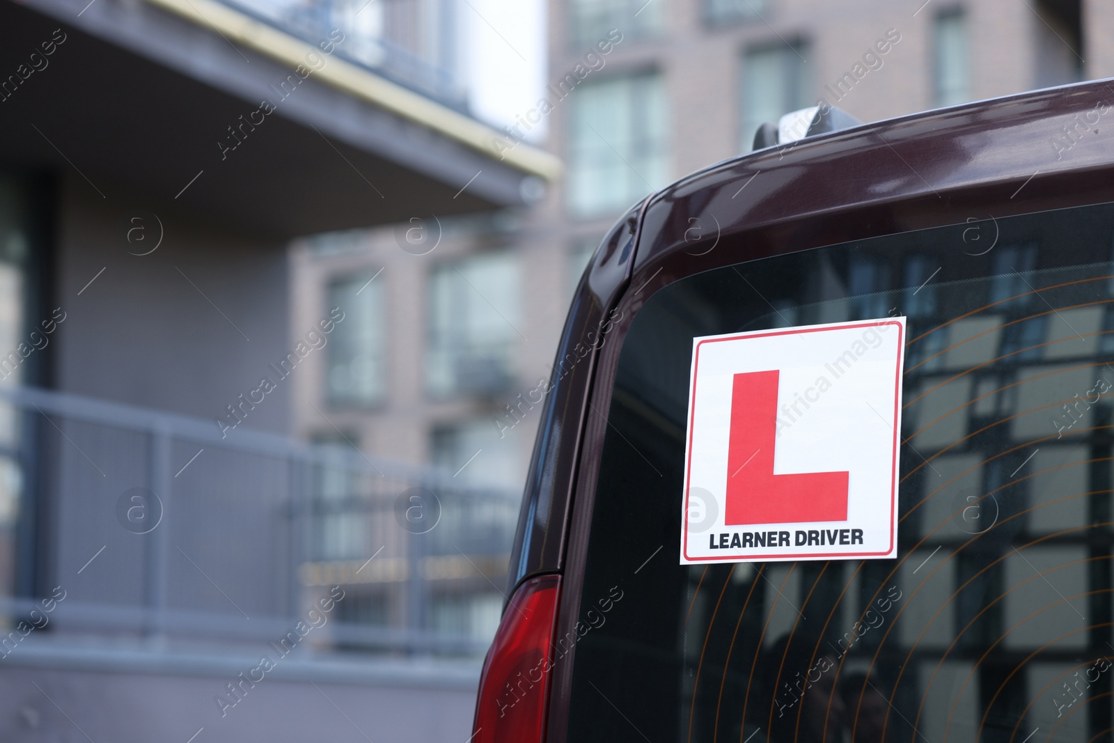 Photo of L-plate on car outdoors, closeup with space for text. Driving school