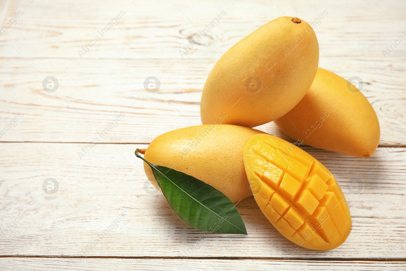 Photo of Composition with fresh mango fruits on wooden background. Space for text