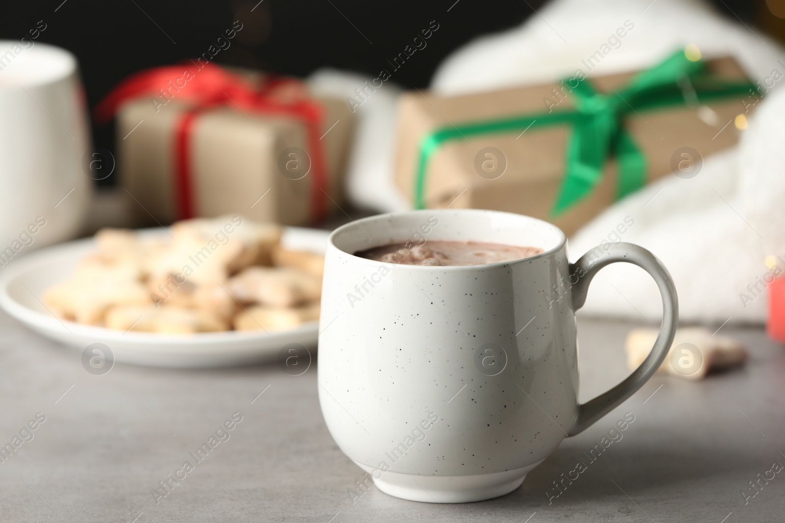 Photo of Delicious cocoa drink in white cup on grey table
