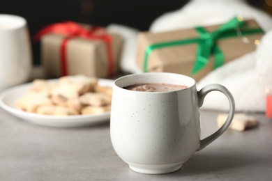 Photo of Delicious cocoa drink in white cup on grey table