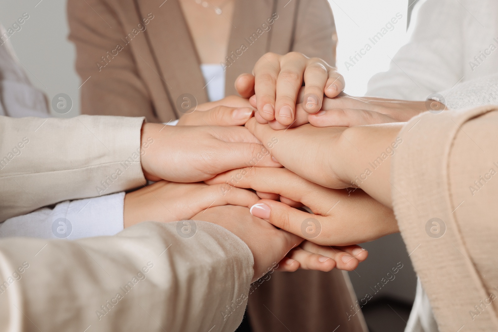 Photo of Group of people holding hands together indoors, closeup. Unity concept