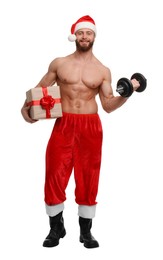 Attractive young man with muscular body in Santa hat holding Christmas gift box and dumbbell on white background