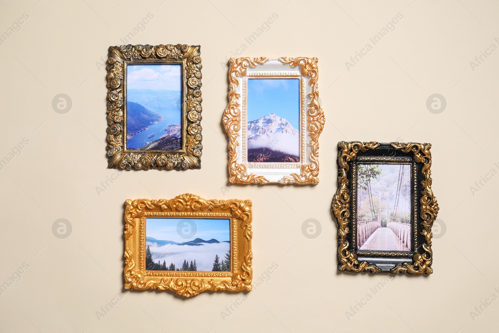 Photo of Vintage frames with photos of beautiful landscapes hanging on beige wall