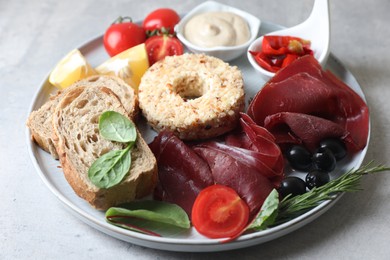 Delicious bresaola and other ingredients for sandwich on light grey table, closeup