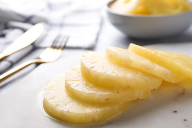 Photo of Delicious canned pineapple rings on marble board, closeup