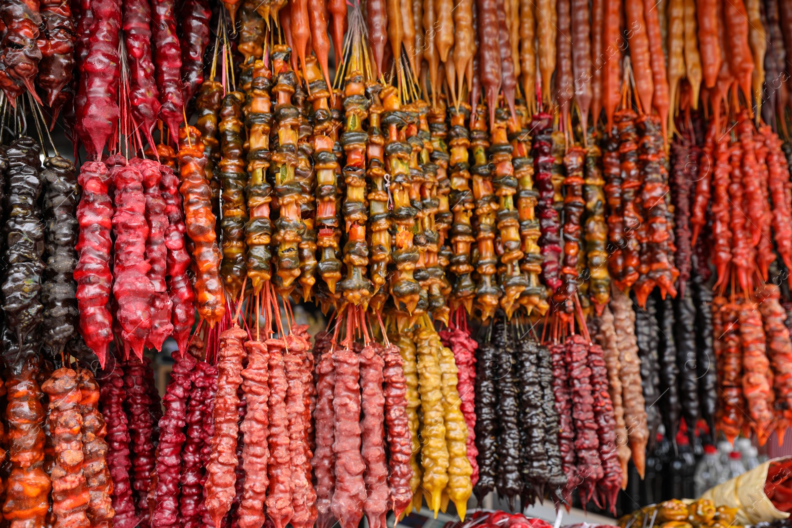 Photo of Bunches of different delicious churchkhelas at market