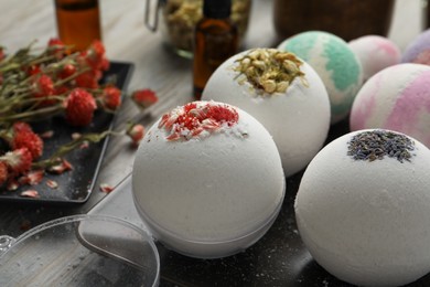 Photo of Plate with different bath bombs on wooden table, closeup