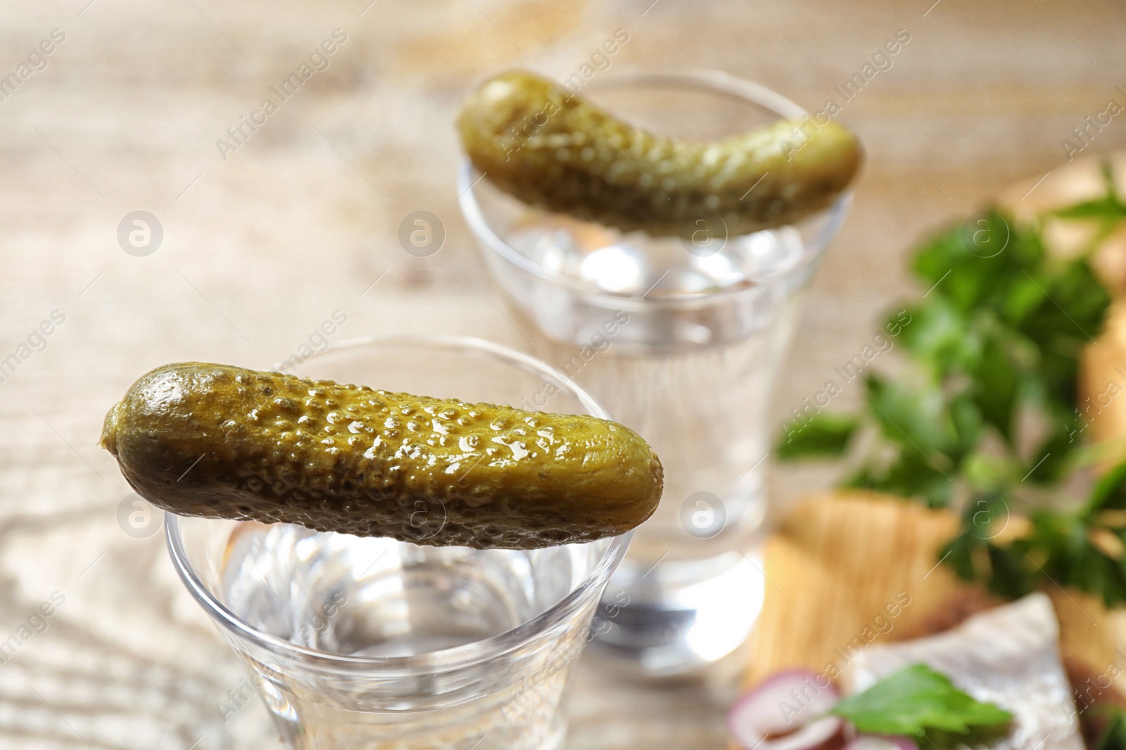 Photo of Cold Russian vodka with pickles on table, closeup