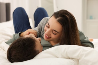 Affectionate young couple spending time together on bed