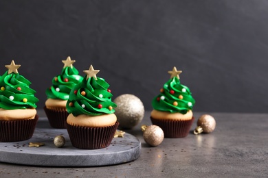 Christmas tree shaped cupcakes on grey table