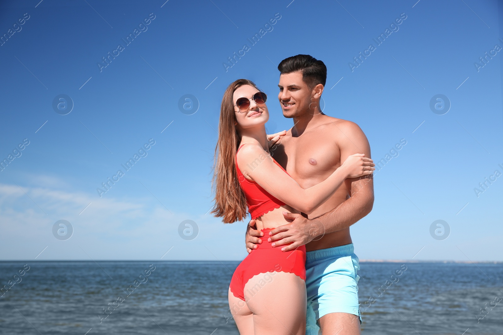 Photo of Beautiful woman and her boyfriend on beach. Happy couple