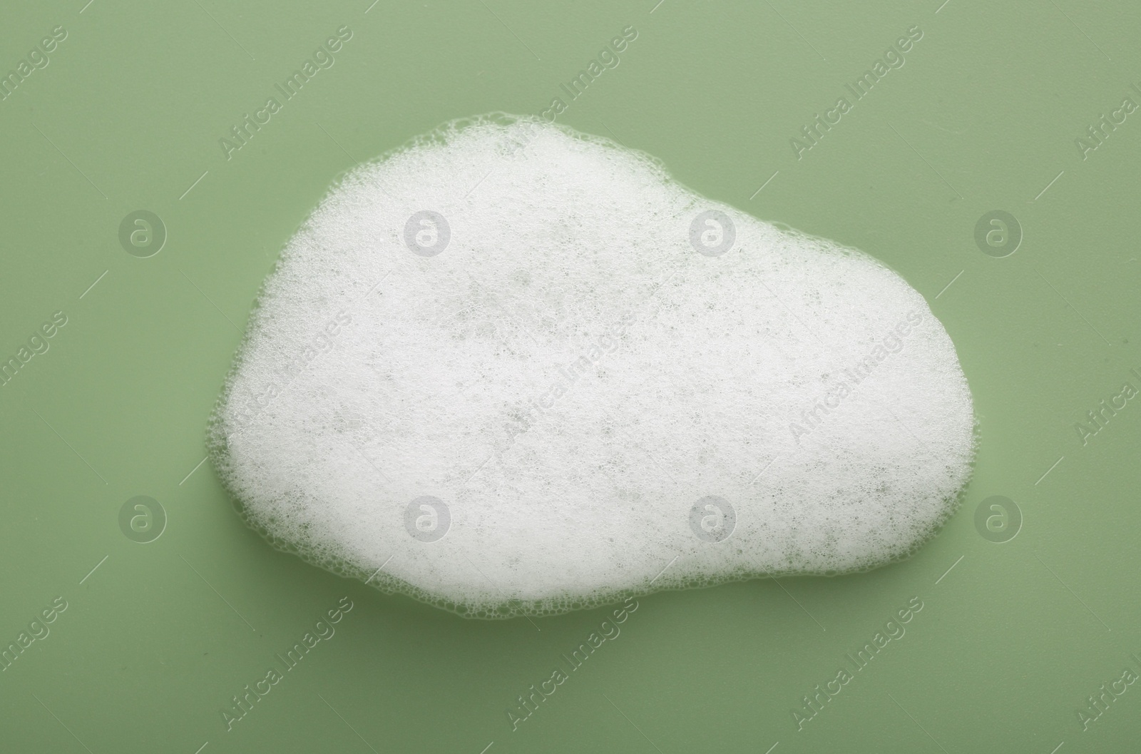 Photo of Sample of fluffy foam on green background, top view