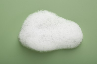 Sample of fluffy foam on green background, top view