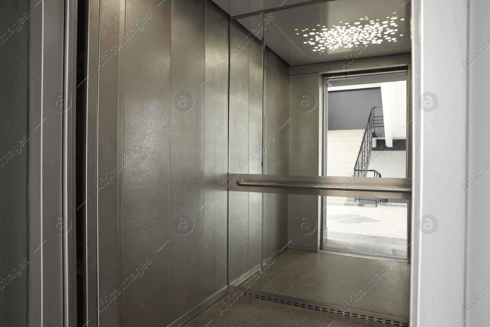 Photo of Open elevator`s cabin with big mirror indoors