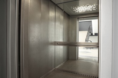 Photo of Open elevator`s cabin with big mirror indoors