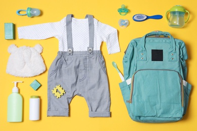 Flat lay composition with baby accessories and maternity backpack on color background