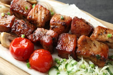 Delicious shish kebabs with vegetables and lavash on wooden board, closeup