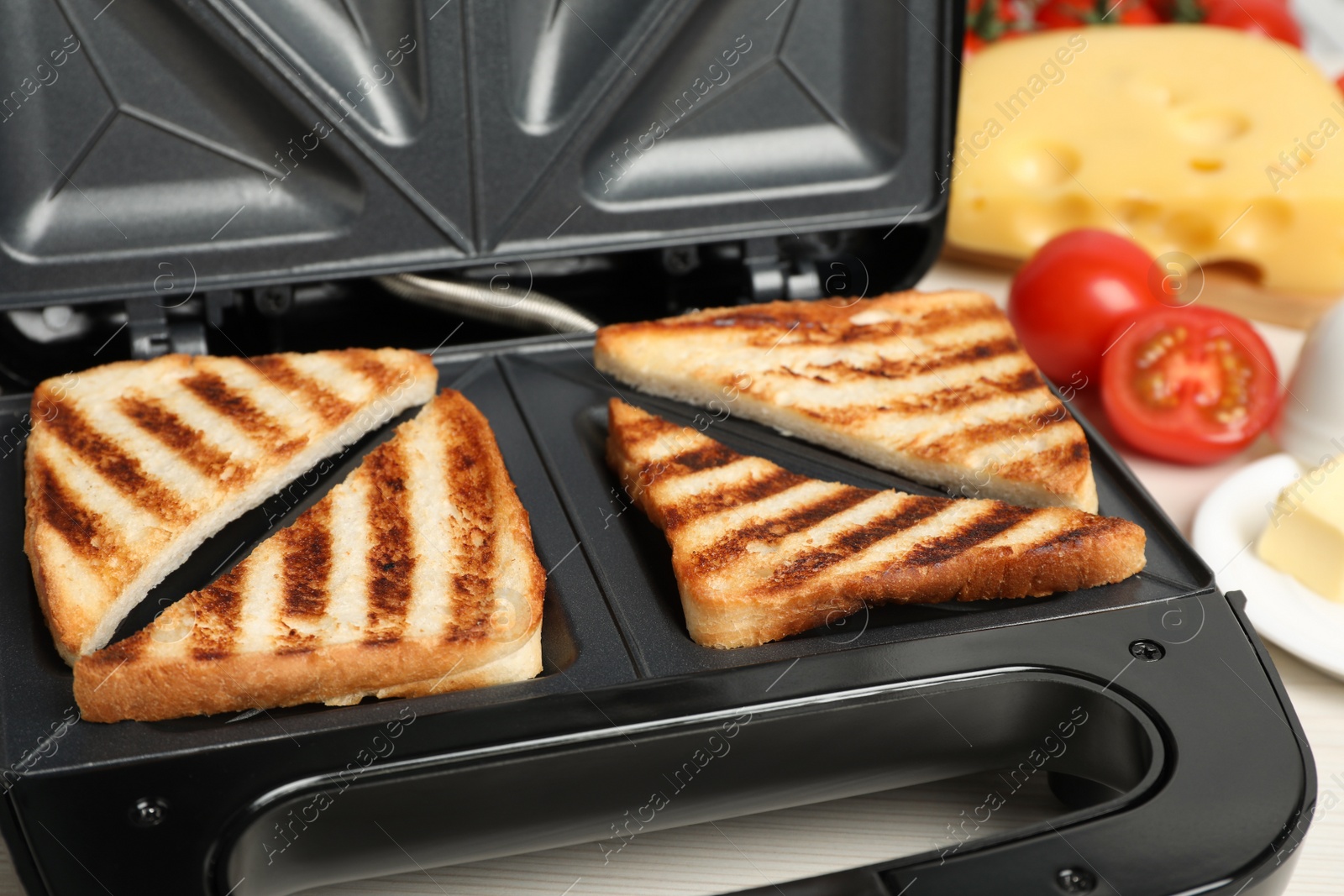 Photo of Modern sandwich maker with bread slices, closeup
