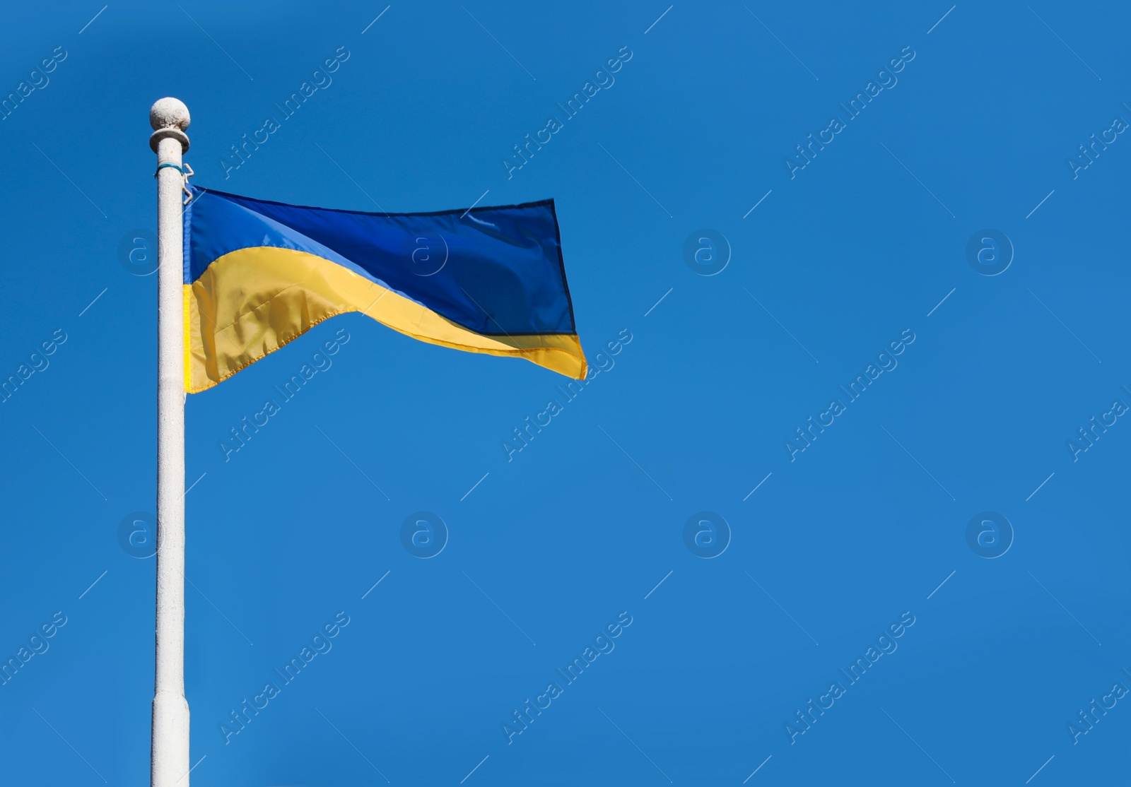 Photo of National flag of Ukraine against clear blue sky. Space for text