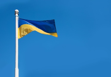 National flag of Ukraine against clear blue sky. Space for text