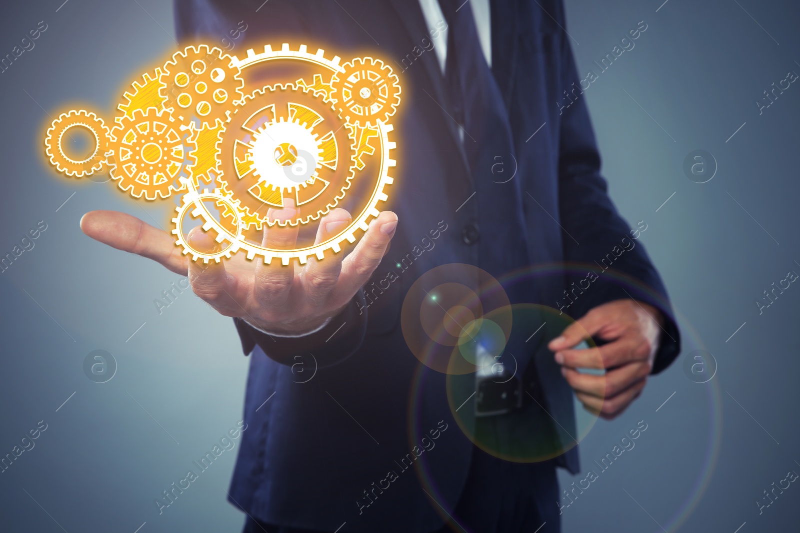 Image of Businessman demonstrating gear mechanism on grey background, closeup