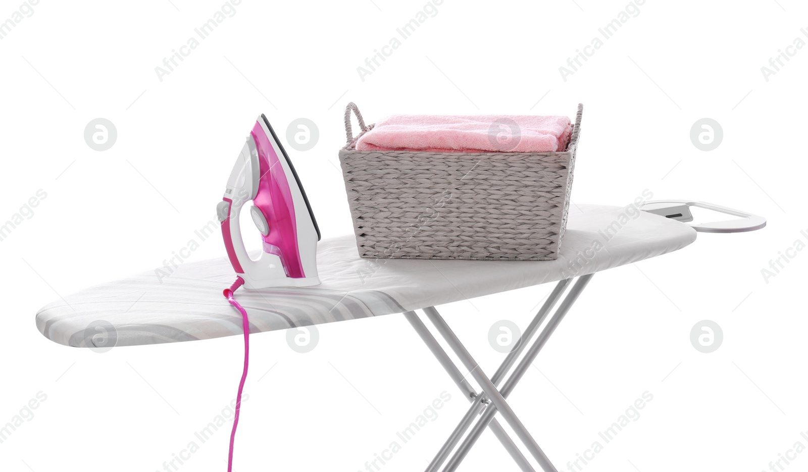 Photo of Board with modern iron and laundry basket on white background