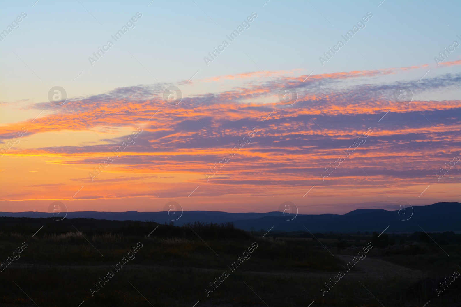 Photo of Picturesque view of landscape under beautiful evening sky with clouds at sunset