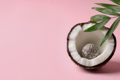 Photo of Composition with delicious vegan candy ball and coconut on pink background. Space for text