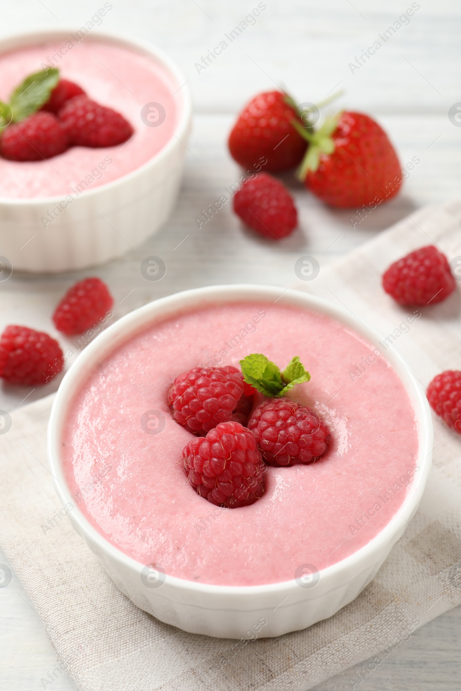 Photo of Delicious berry mousse with mint on white wooden table