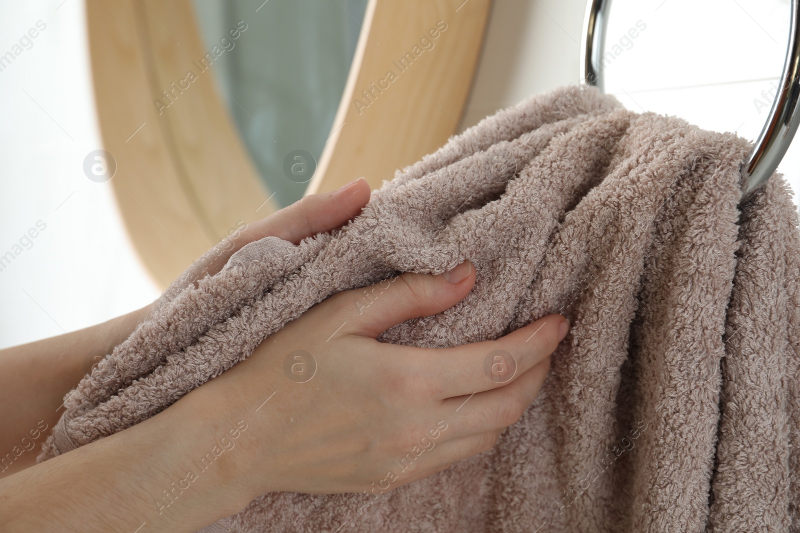 Photo of Woman wiping hands with towel in bathroom, closeup