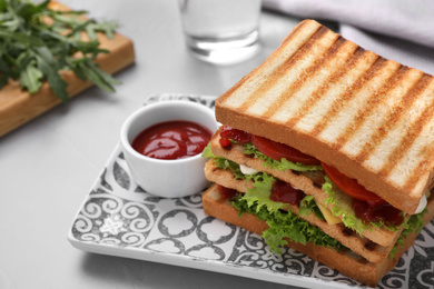 Photo of Yummy sandwich with tomato sauce served on grey table