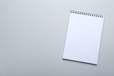 Photo of One notebook on light grey background, top view. Space for text