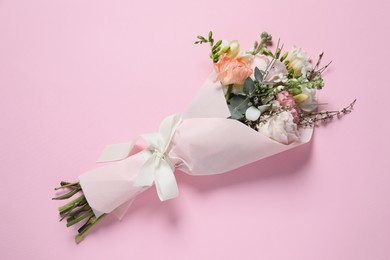 Bouquet of beautiful flowers on pink background, top view