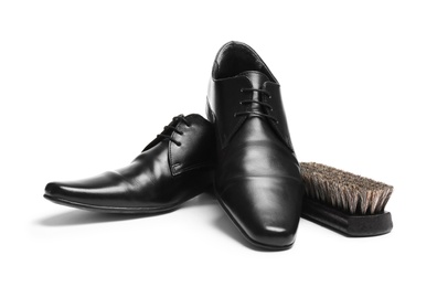 Photo of Stylish men's shoes and cleaning brush on white background