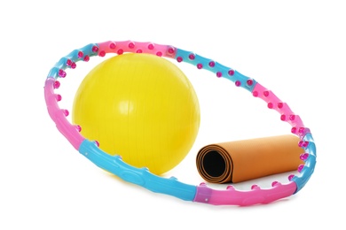 Hula hoop, fitness ball and mat on white background