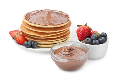 Photo of Tasty pancakes with chocolate paste and berries isolated on white