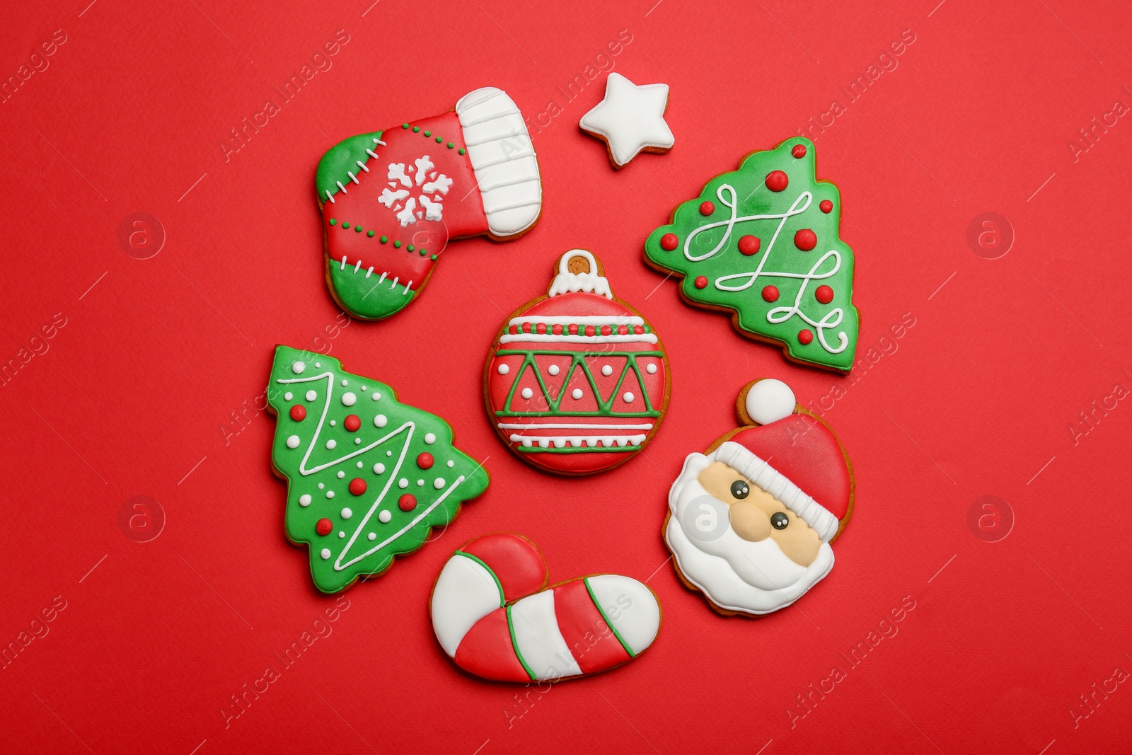 Photo of Different tasty Christmas cookies on red background, flat lay