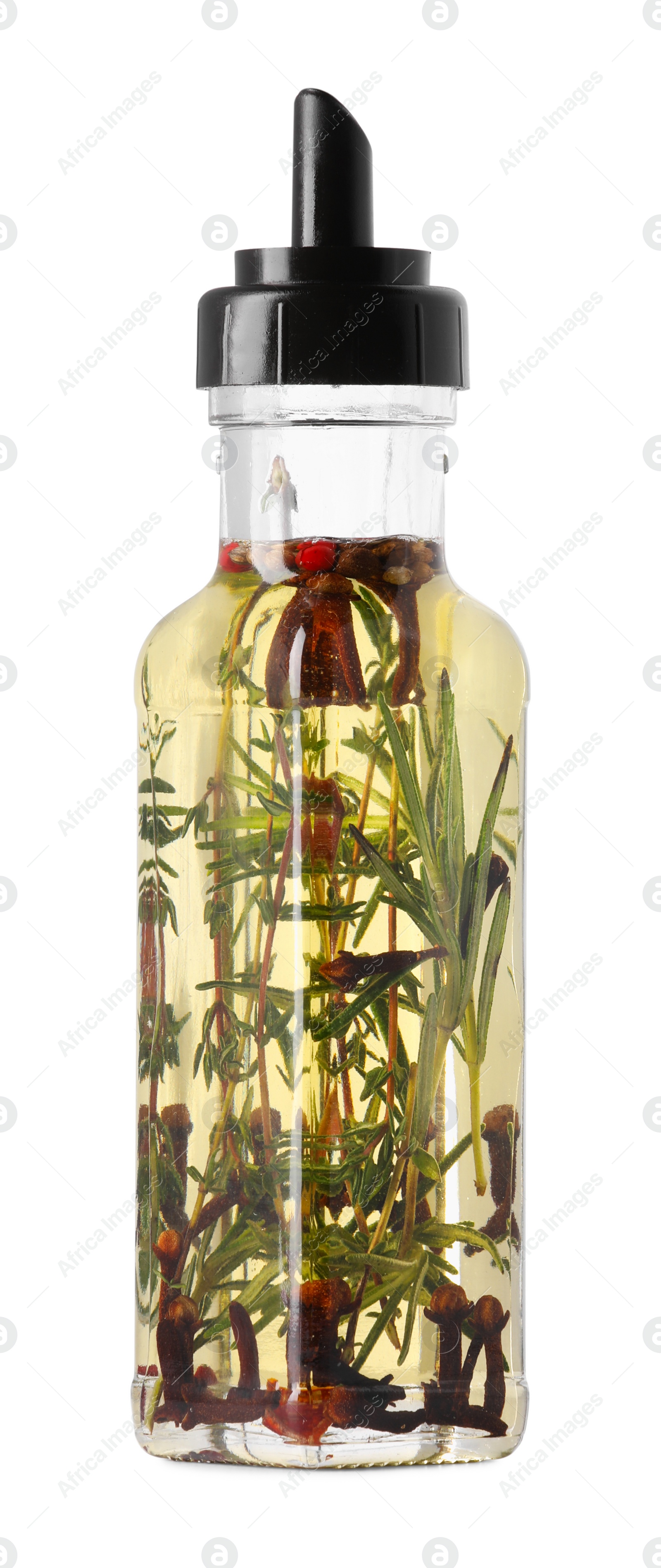 Photo of Glass bottle of cooking oil with spices and herbs isolated on white