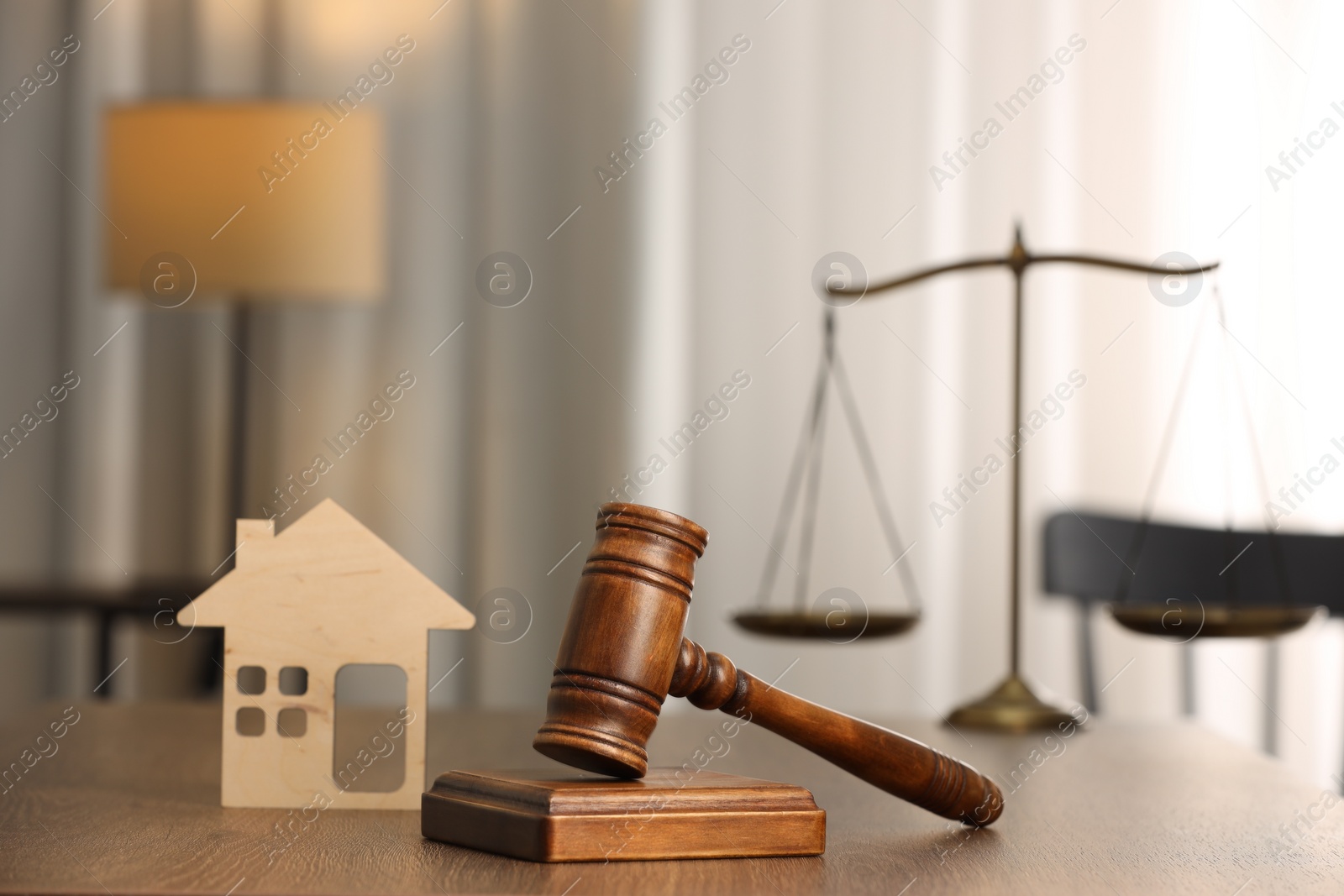 Photo of Law concept. Gavel and figure of house on wooden table