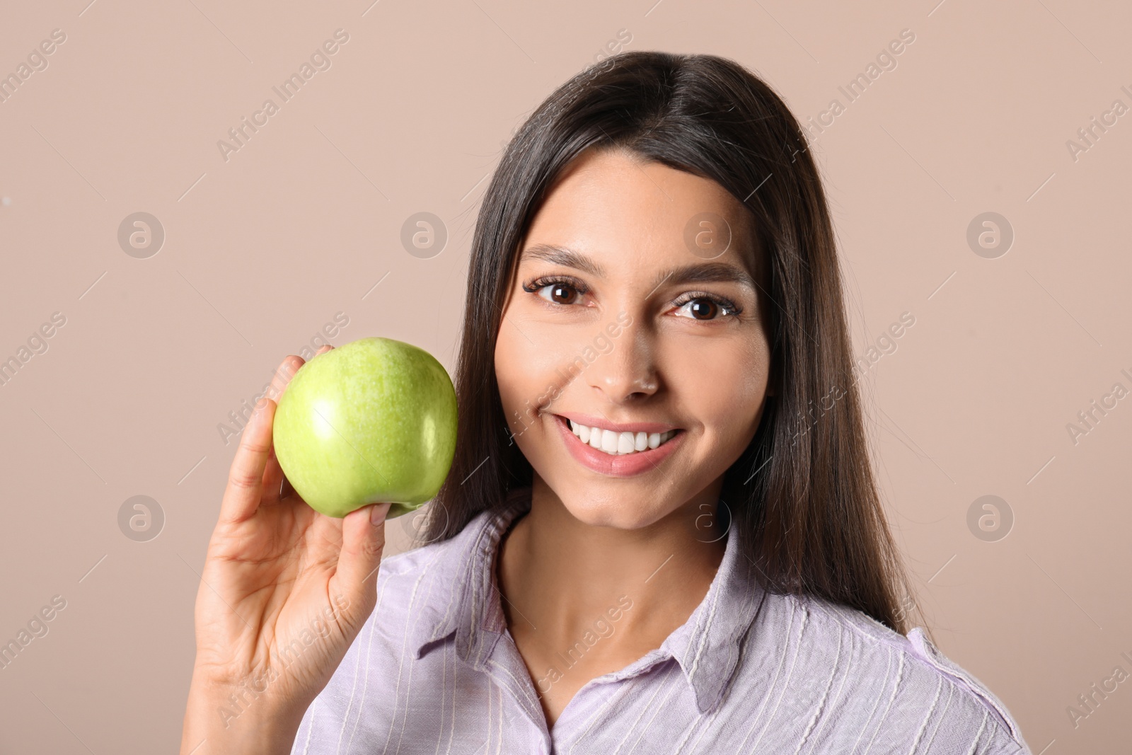 Photo of Young woman with healthy teeth and apple on color background