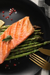 Photo of Tasty grilled salmon with asparagus and spices served on table, top view