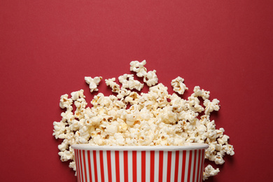 Photo of Delicious popcorn on red background, top view