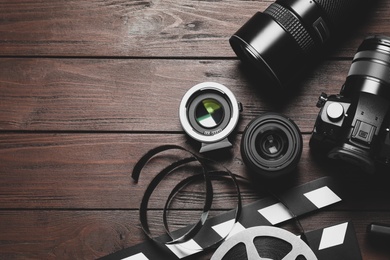 Photo of Flat lay composition with camera and video production equipment on brown wooden background. Space for text